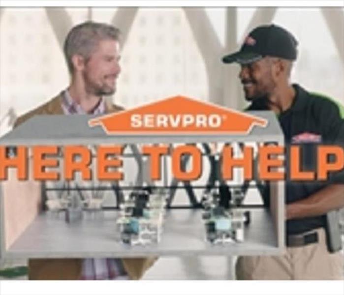 2 men looking at each other with the SERVPRO logo in front of them